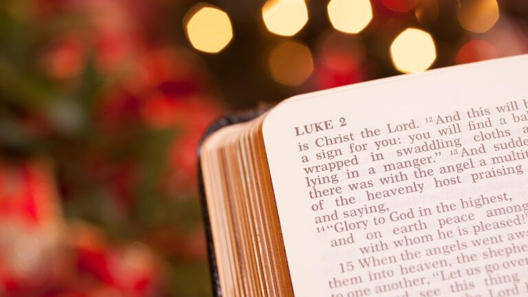 A open Bible with Christmas lights in the background
