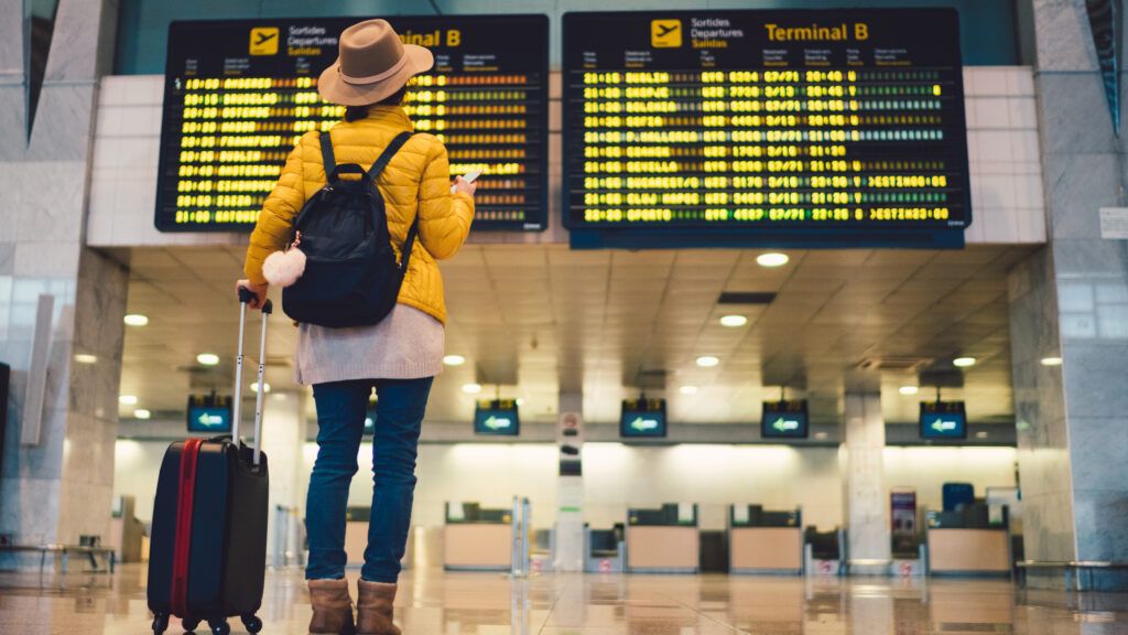 Woman looking at departure board in airport