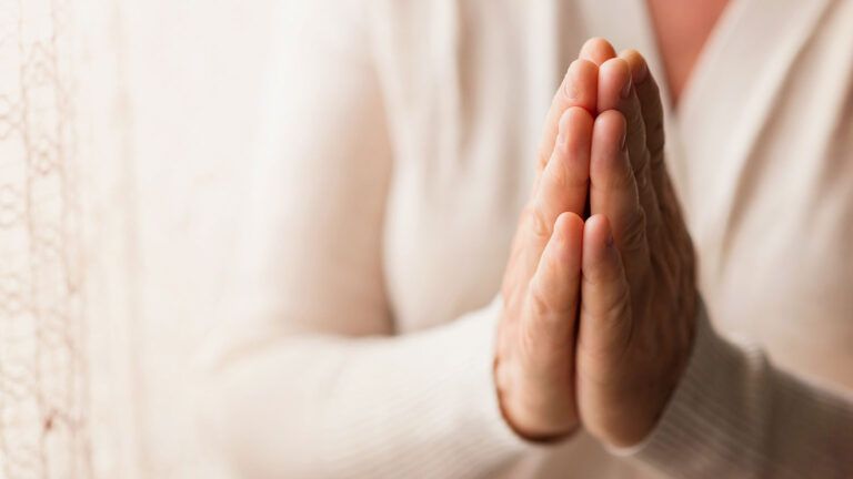 Closeup of a woman's hands clasped in prayer
