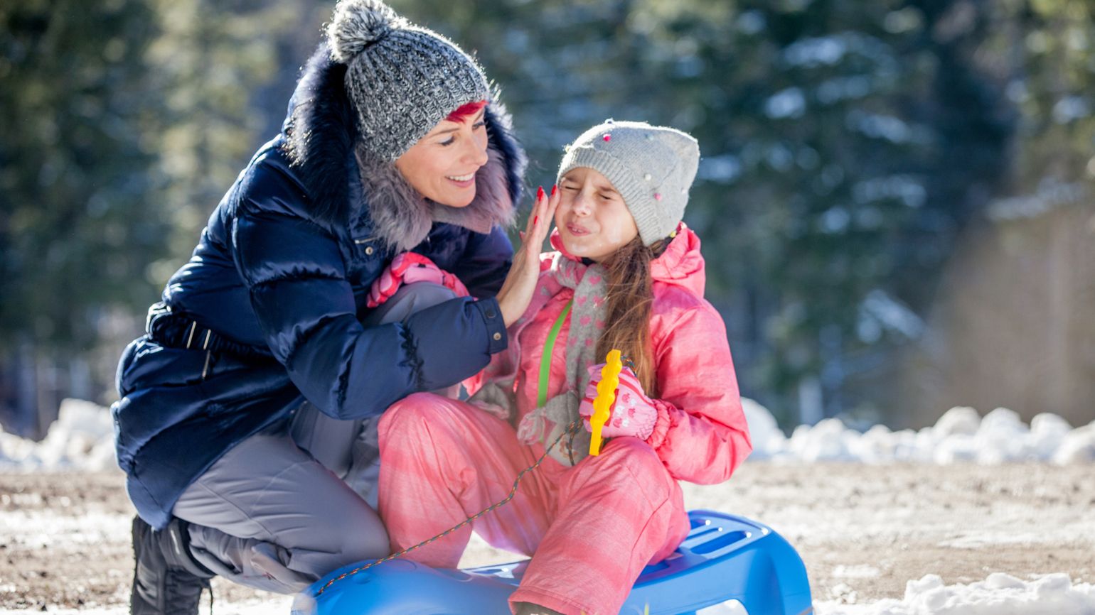 Health myths about Winter: Skip the Sunscreen. Mother applying sunscreen to daughter in winter. better living health wellness
