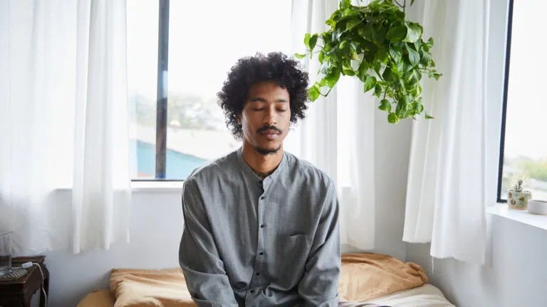 Man sitting in his bed and saying prayers for fasting