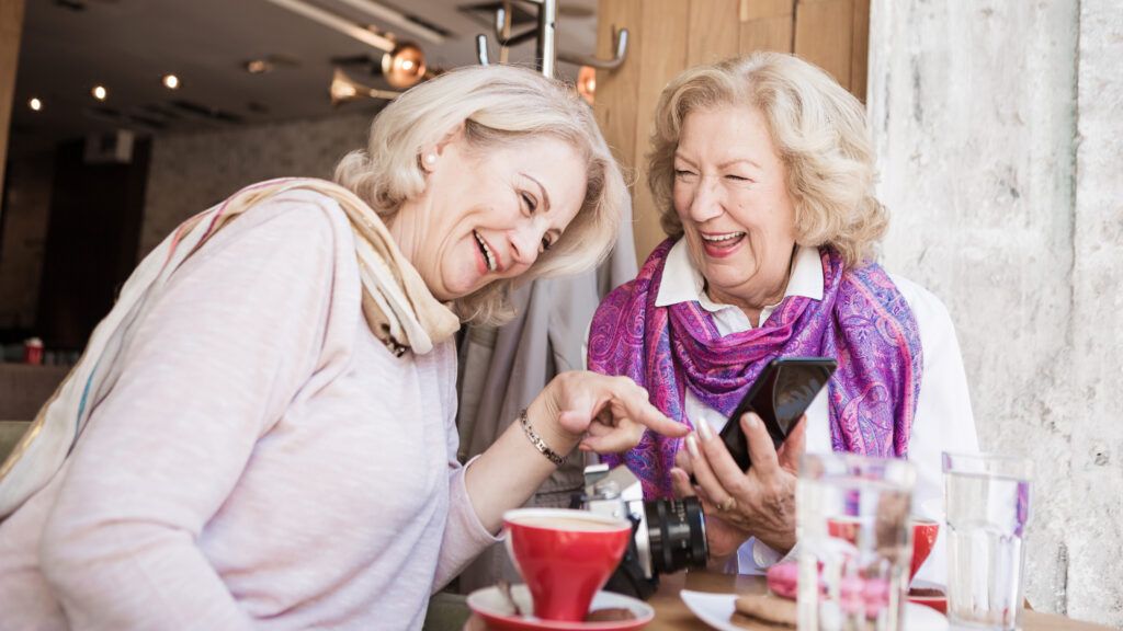 Two woman laughing over coffee