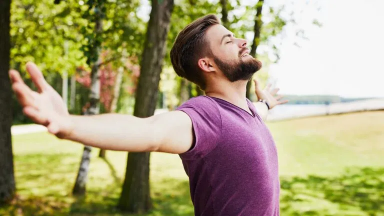 Man with his arm outstretched saying his spring prayers outside