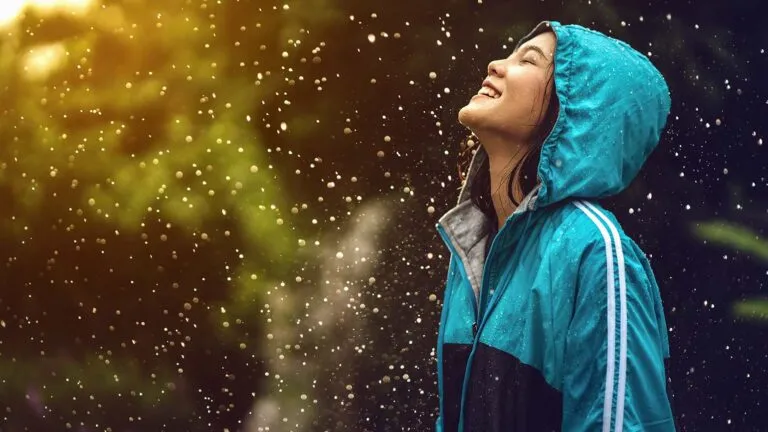 Woman saying her spring prayers while facing up into the rain