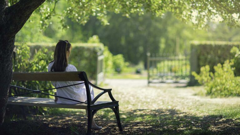 Woman sitting on a park bench saying her spring prayers