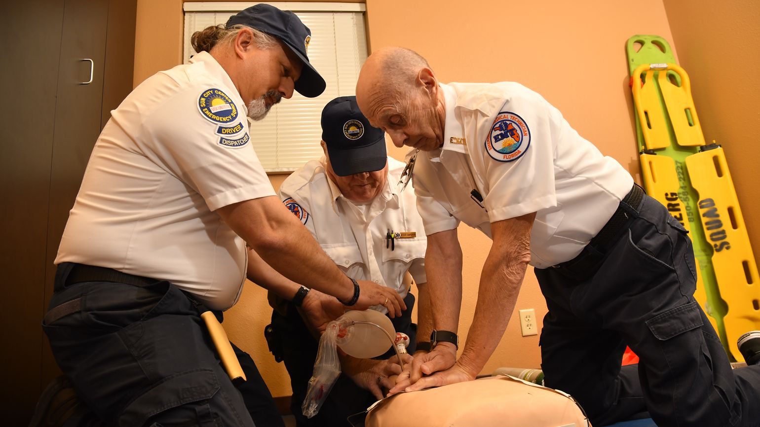 Captain Robert Leonard leading a team in a CPR drill. The EMR, EMT, and ambulance driver all have roles providing lifesaving CPR to a patient.