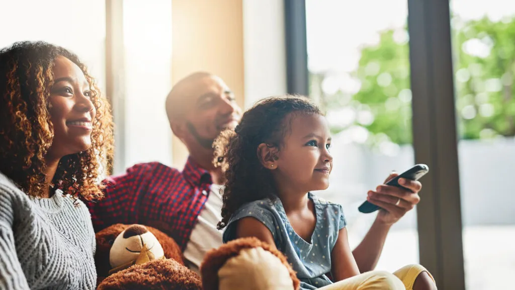 A family of three watches TV together.