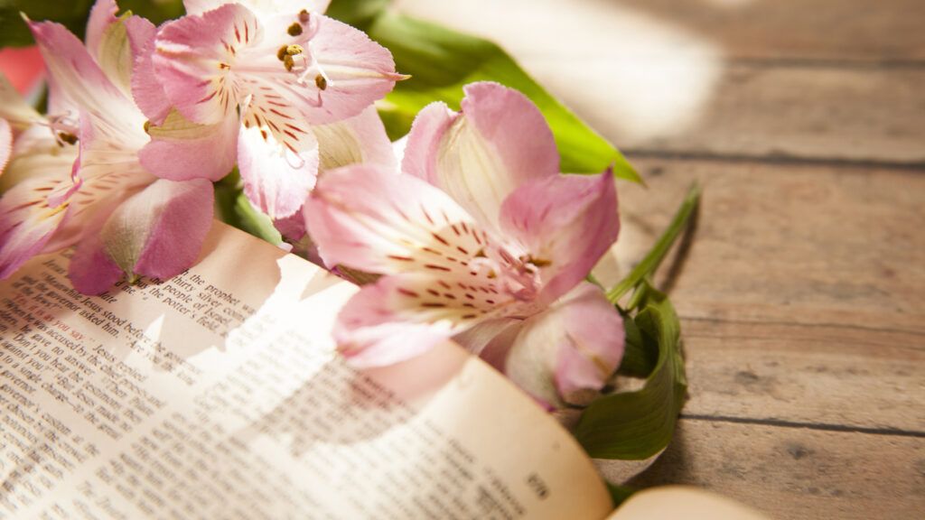 A Bible surrounded by spring flowers.