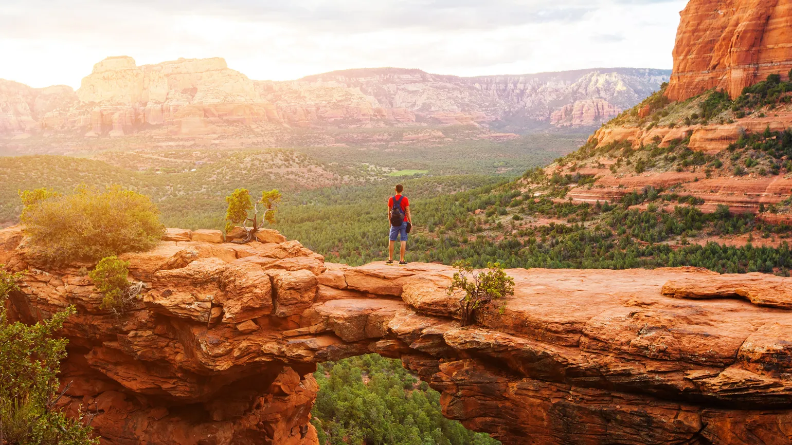 A backpacking adventurer hiking through a canyon.