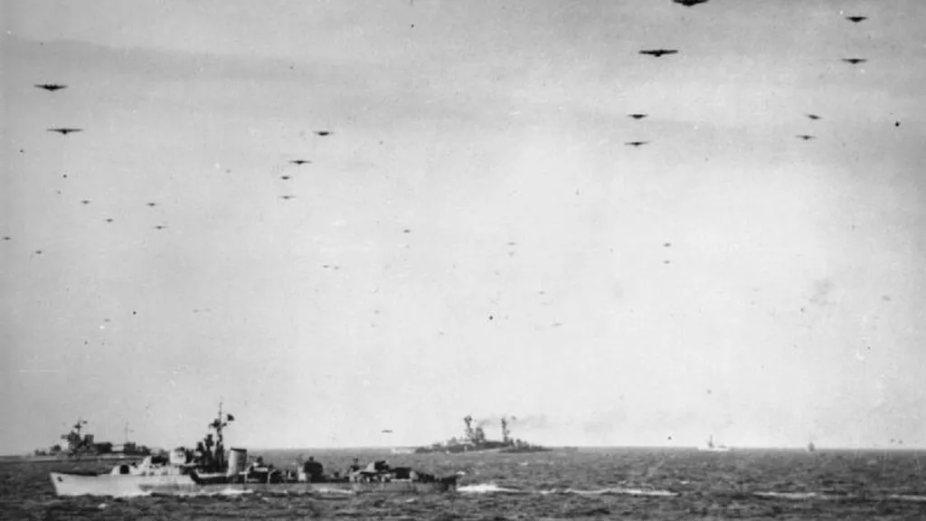 The Royal Navy during the Second World War- Operation Overlord (the Normandy Landings)- D-day 6 June 1944 Glider borne troops passing over units of the Royal Navy on their way to the invasion beaches of Normandy. In the background are the battleships HMS