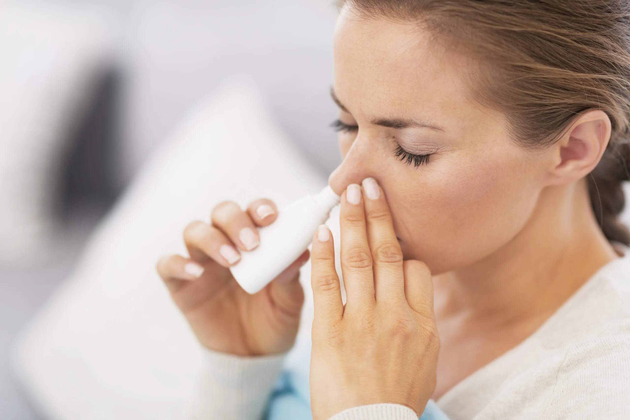 Woman using nasal spray