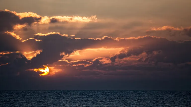 The sun setting behind the clouds.