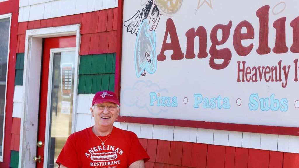 Paul standing by the Angelina sign in front of his business.