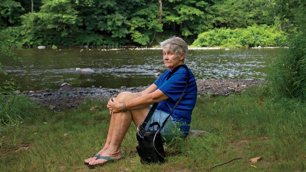Judy sits on the banks of the Farmington River