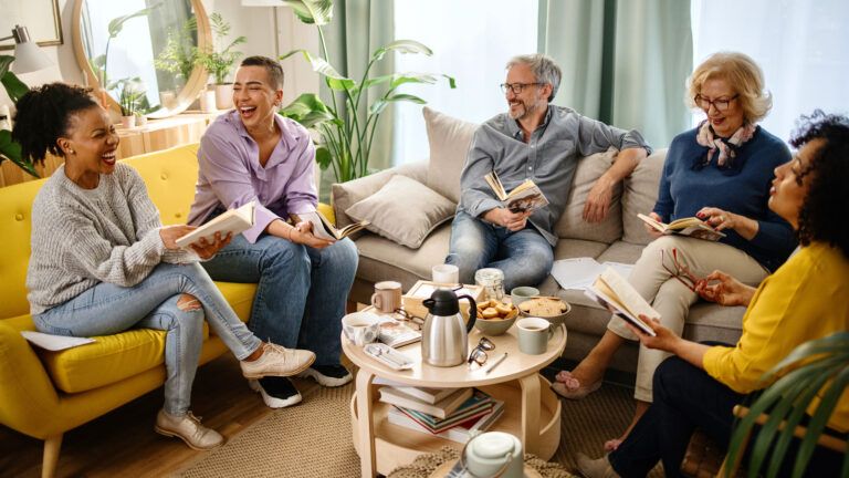 A group of smiling people do their reading habits in a book club