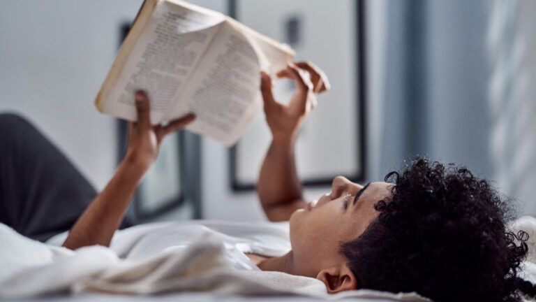 Man lying in bed does his reading habit with a book