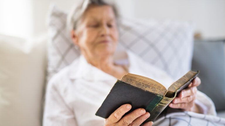A senior woman reads a well-worn Bible
