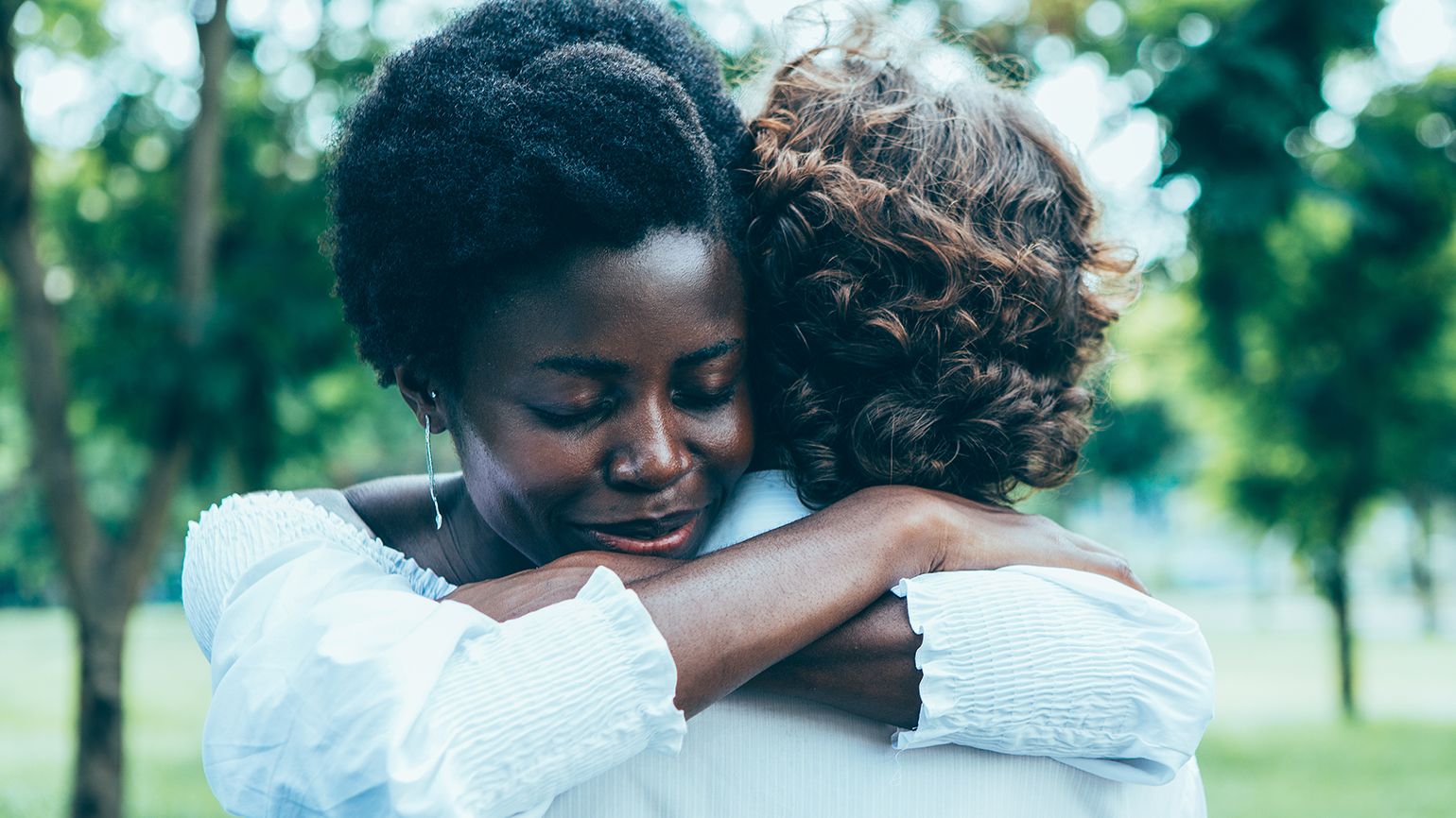 Two women engage in a forigiving hug