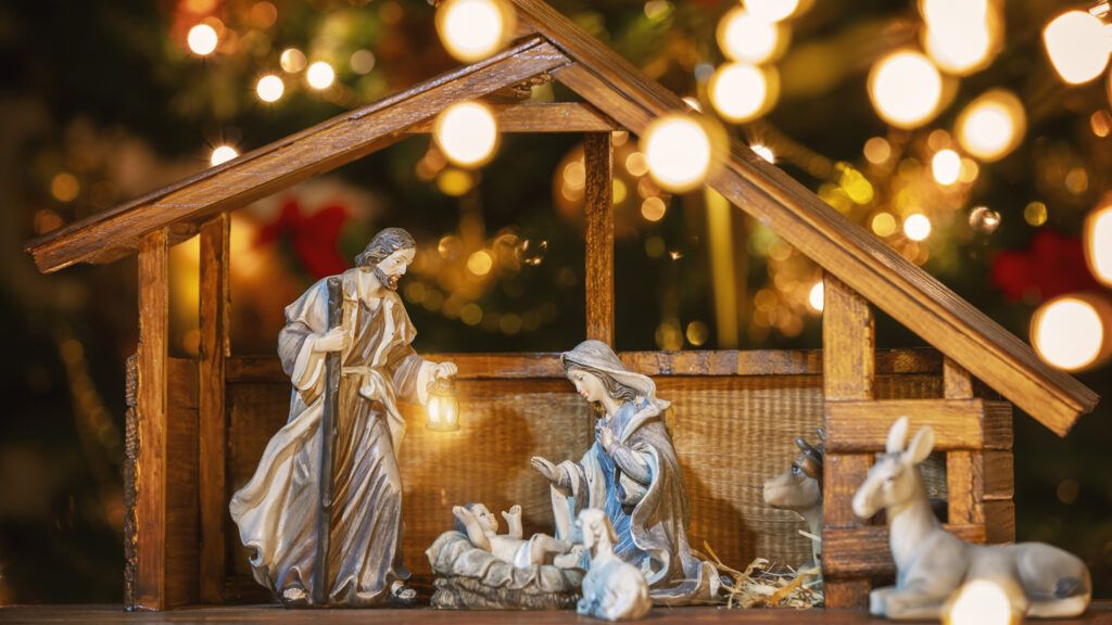 Christmas Manger scene with figurines including Jesus, Mary, Joseph and sheep.