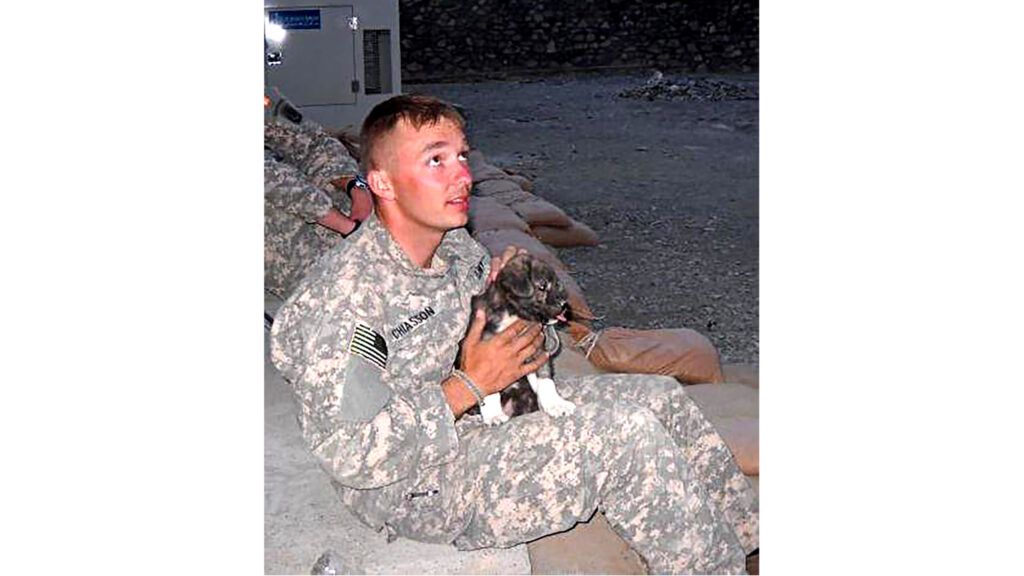 Chris in fatigues with Bear as a puppy.