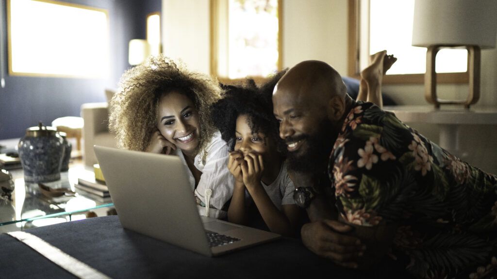 Family smiling at computer screen