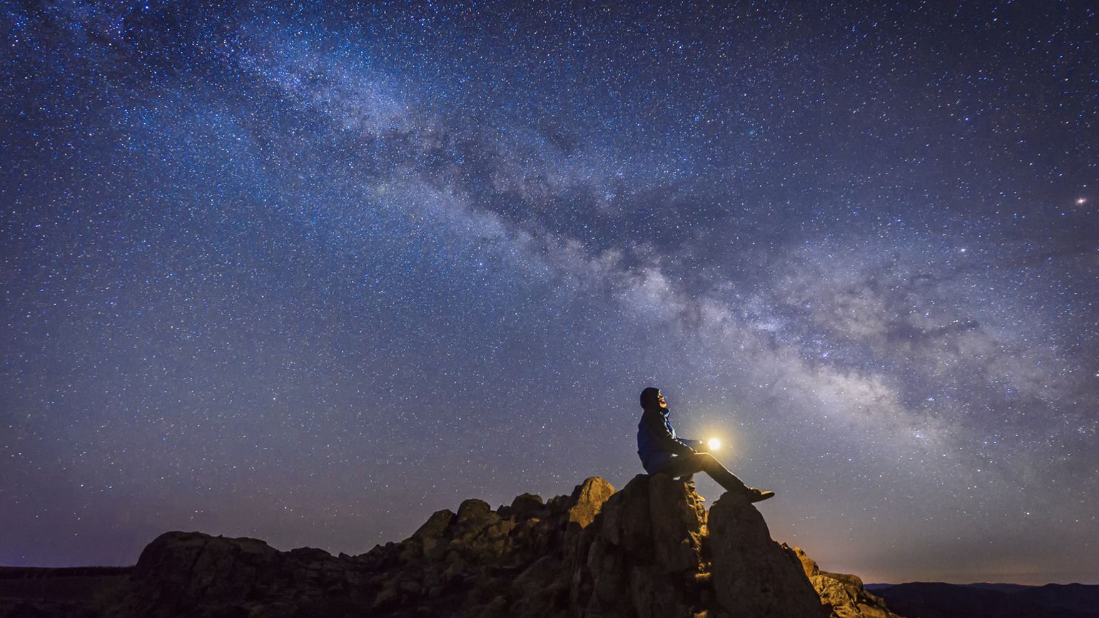 A man observing a starlit night.