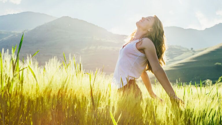 A joyful woman basks in the sunlight