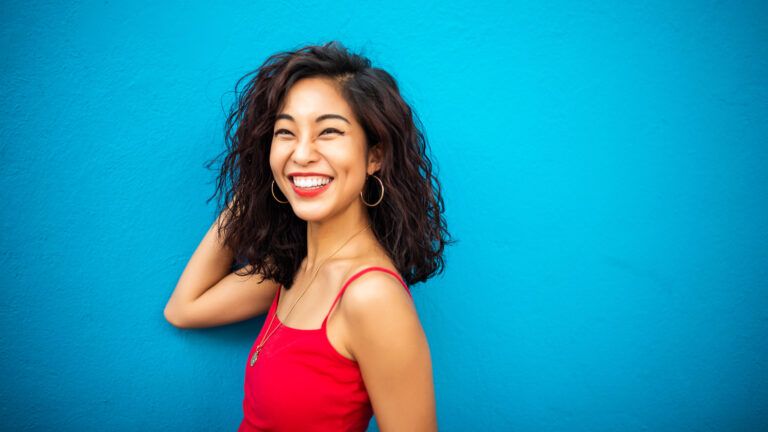 Smiling woman in a red shirt on a blue background celebrates different types of Valentines
