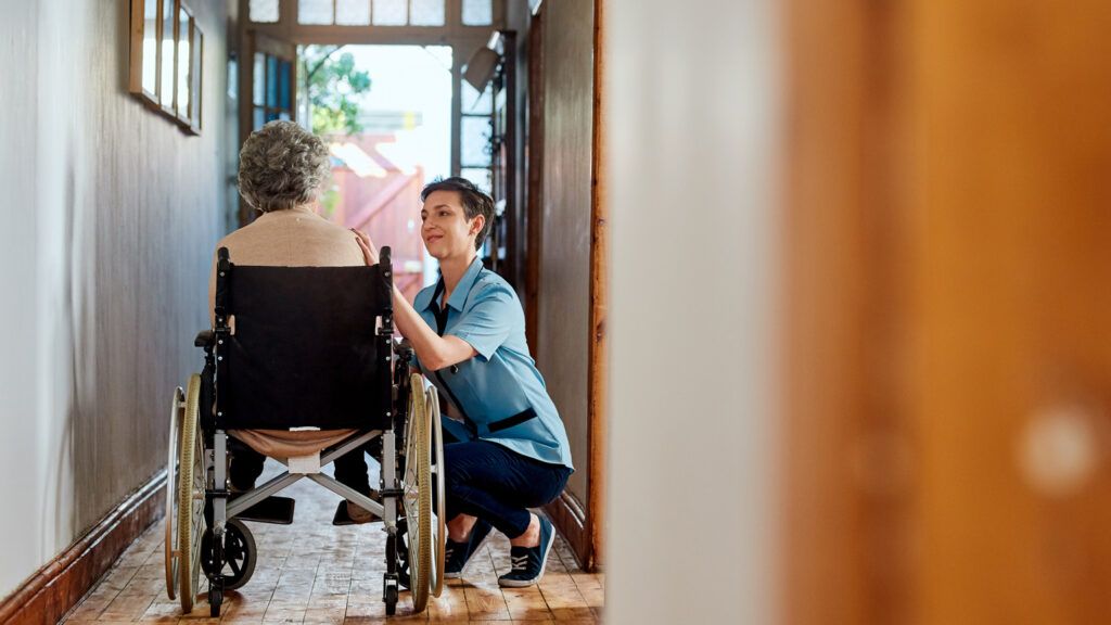 An aging woman in a wheelchair recieving in home care.
