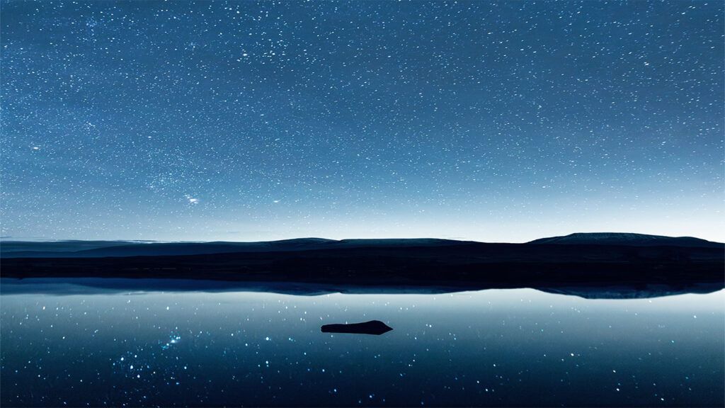 A peaceful lake landscape with various shades of blue.