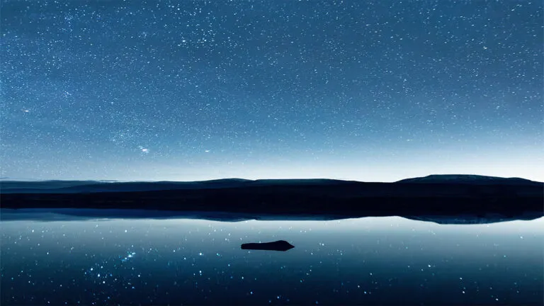 A peaceful lake landscape with various shades of blue.