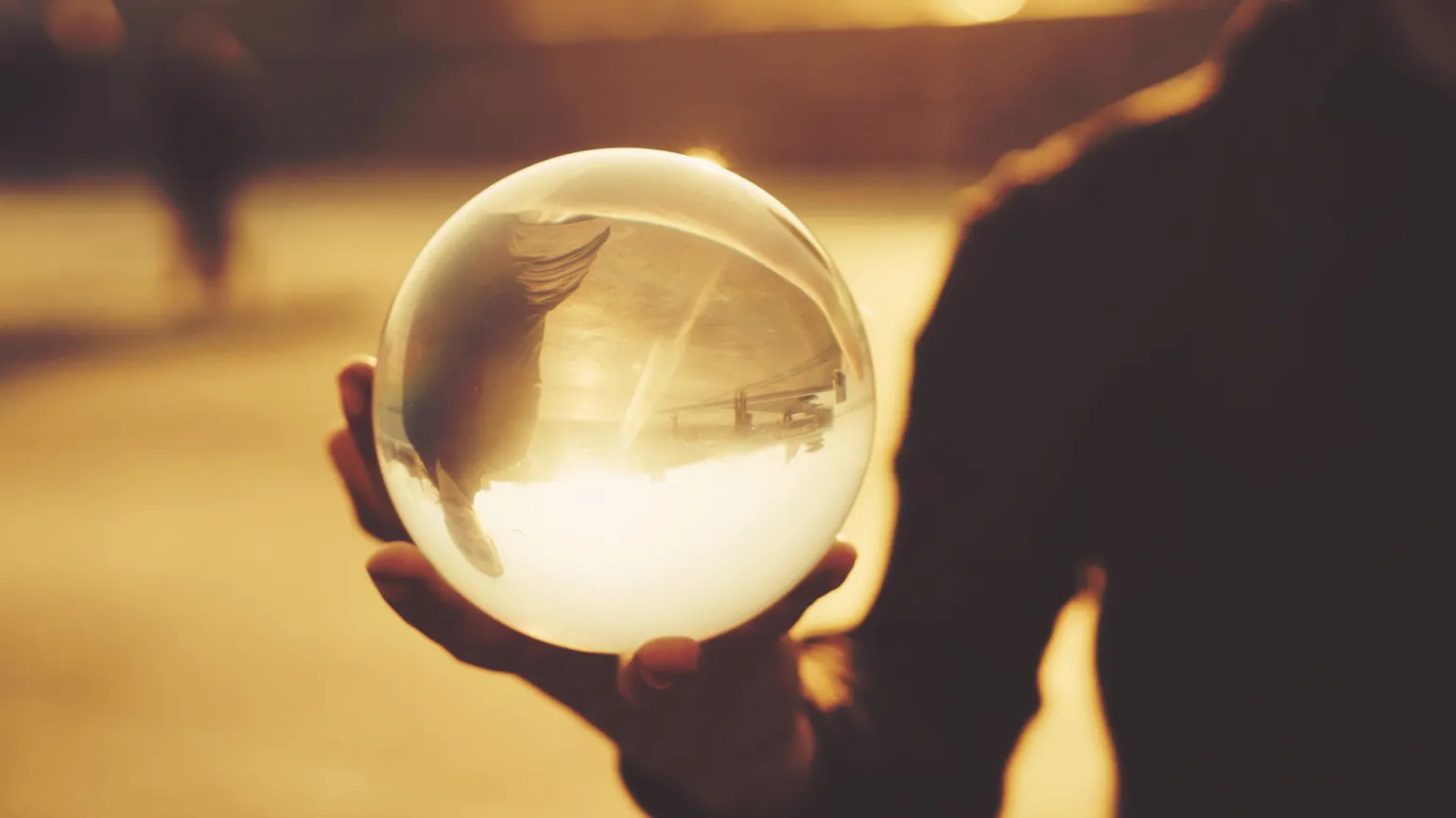 Man balancing a glass bowl in his hand.