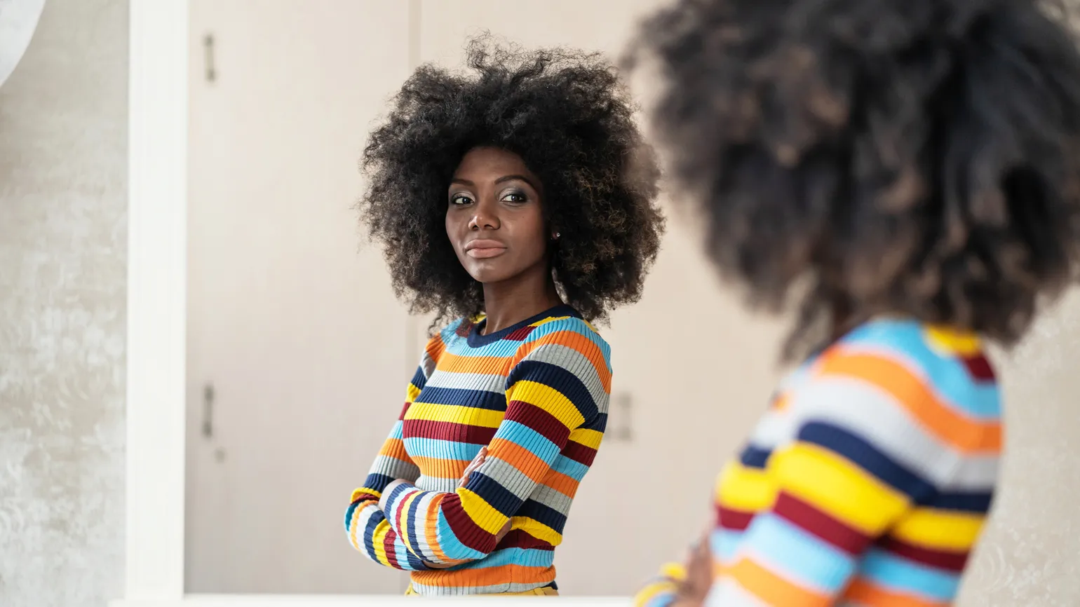 Woman looking at her reflection in the mirror.