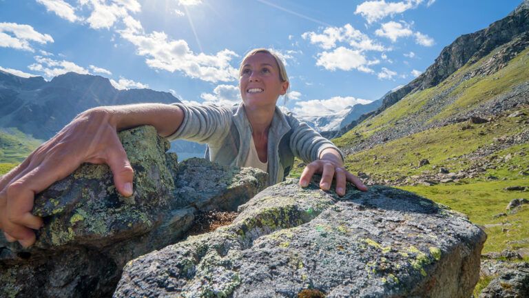 A woman rock-climbs on a mountain