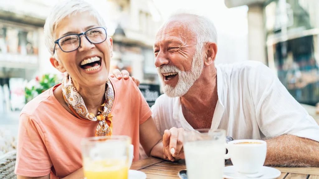 A mature woman and man enjoy a laugh together