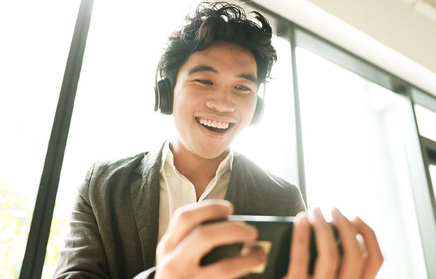 Young man joyfully watching a video on his phone