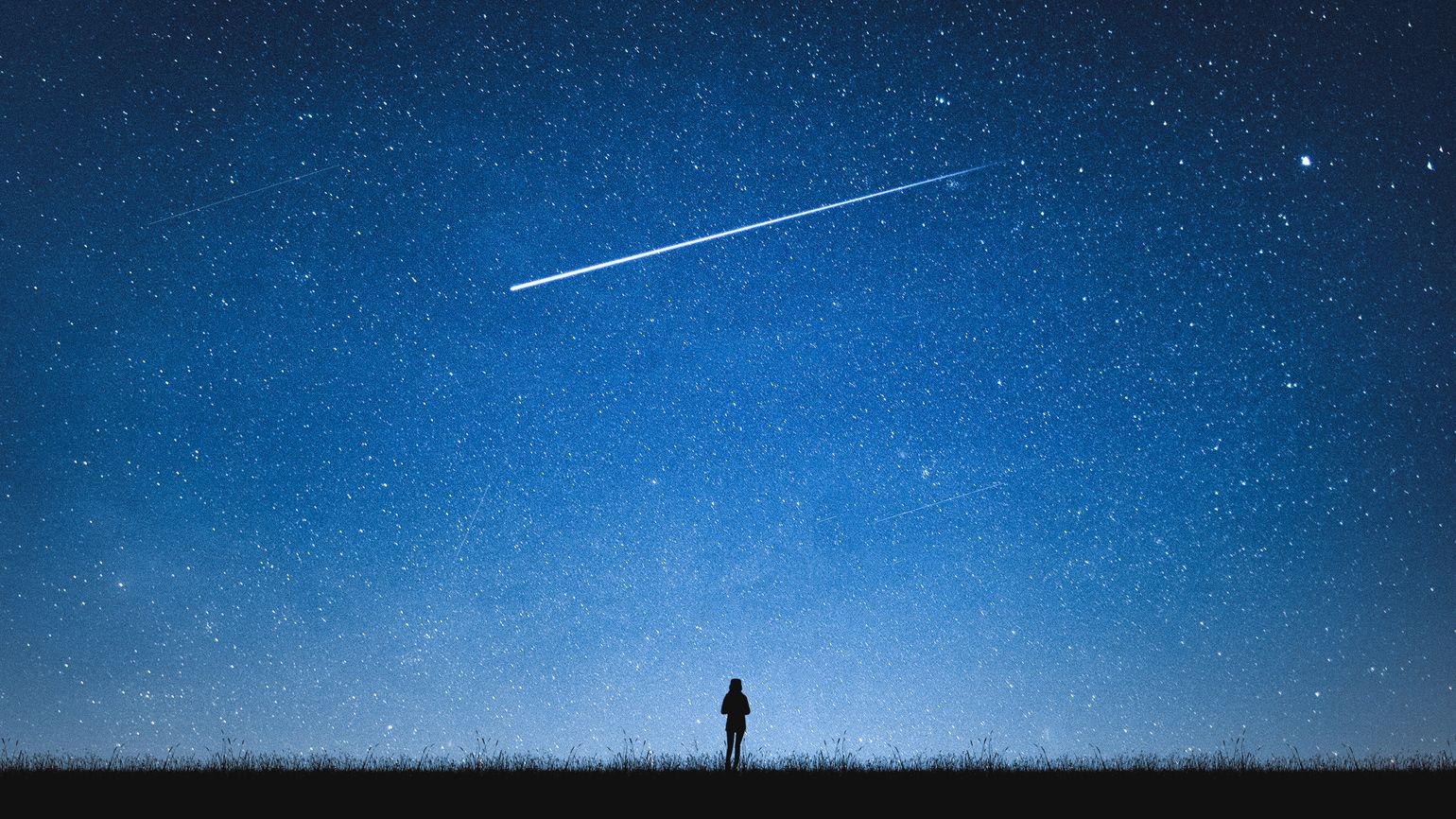 A silouette of a girl observing the night sky with a shooting star.