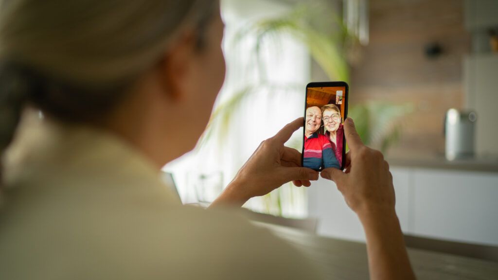 A woman video chatting with her aging parents.
