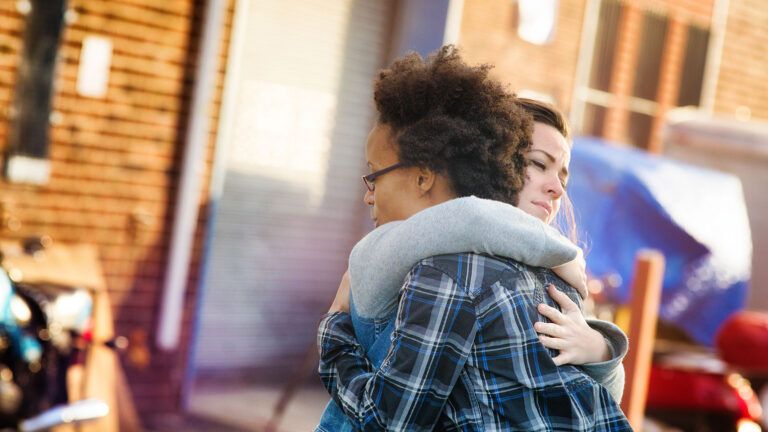 Two women embrace in a forgiving hug