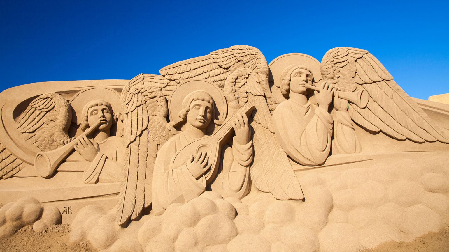 Visitors admire Belen de Arena, Nativity scenes made of sand, on Las Canteras town beach.
