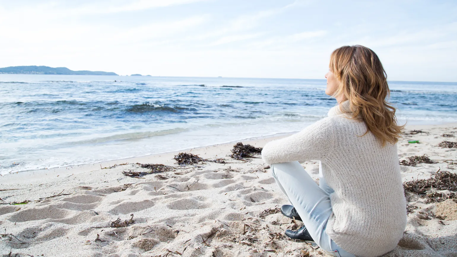 Woman sitting alone at the beach.