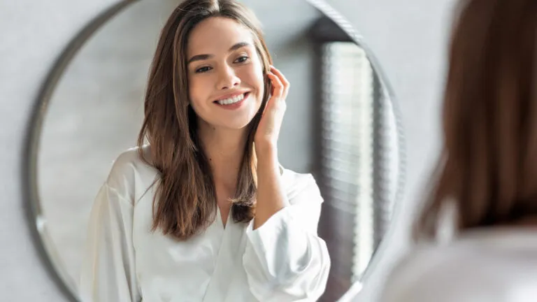 Woman looking in a mirror ready to spiritually change her life in 2023