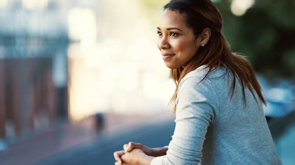 A smiling woman outside preparing to spiritually change her life in 2023