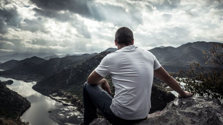 A contemplative man looks out over a valley