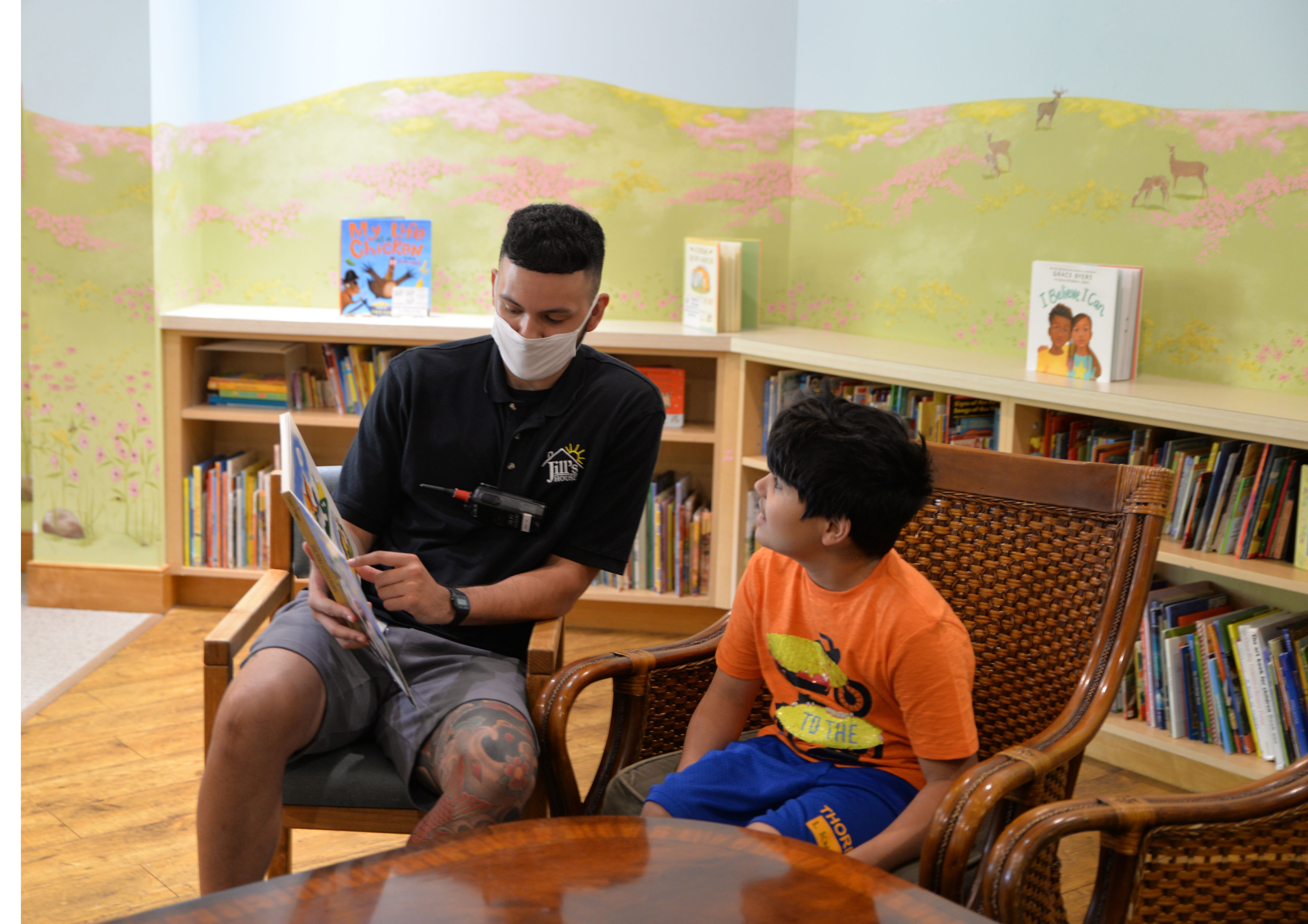 Jill's House volunteer reading a book with a child