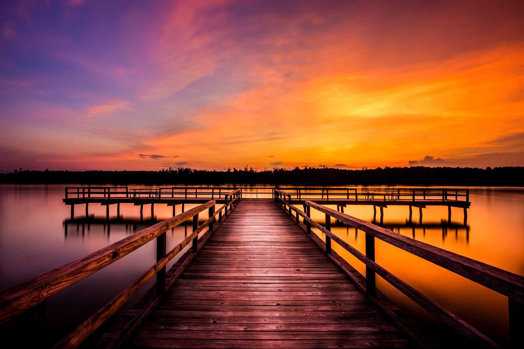 A dock overlooking a sunset over water; Getty Images