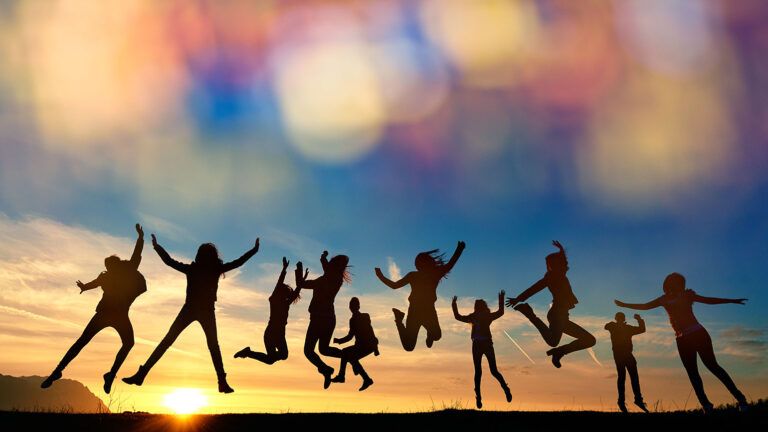 A group of friends leap for joy at sunrise