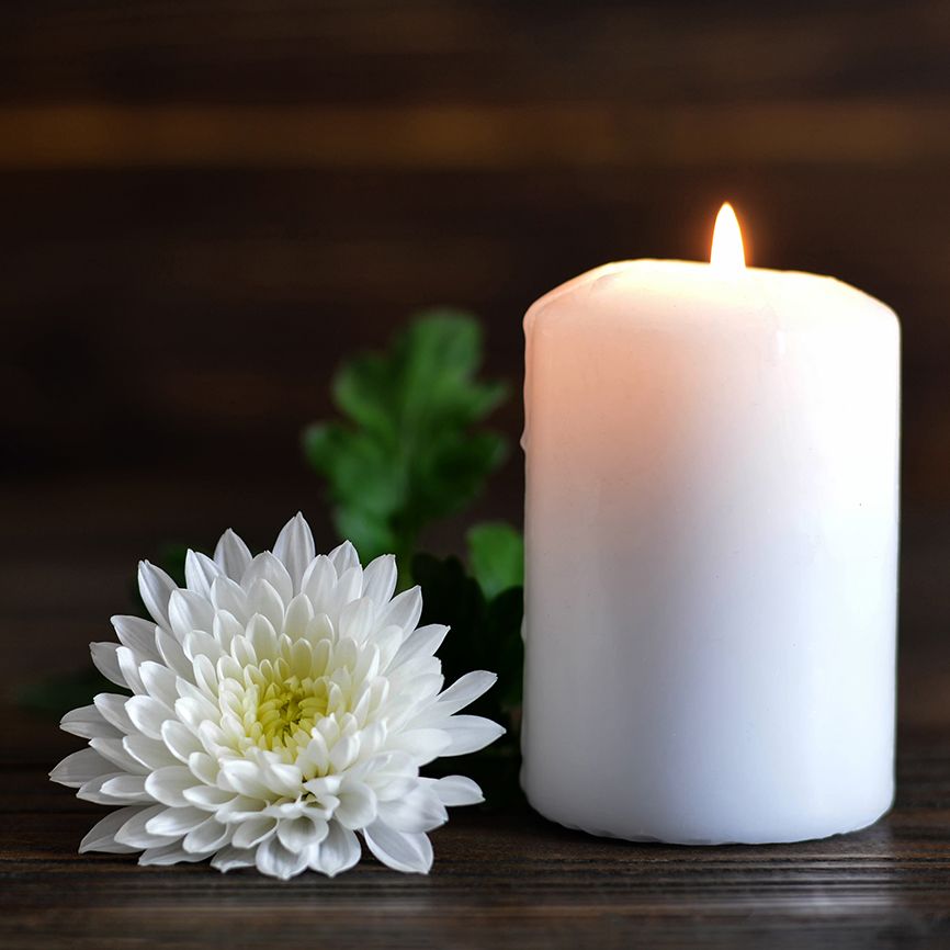 A flower and a candle, lit in remembrance
