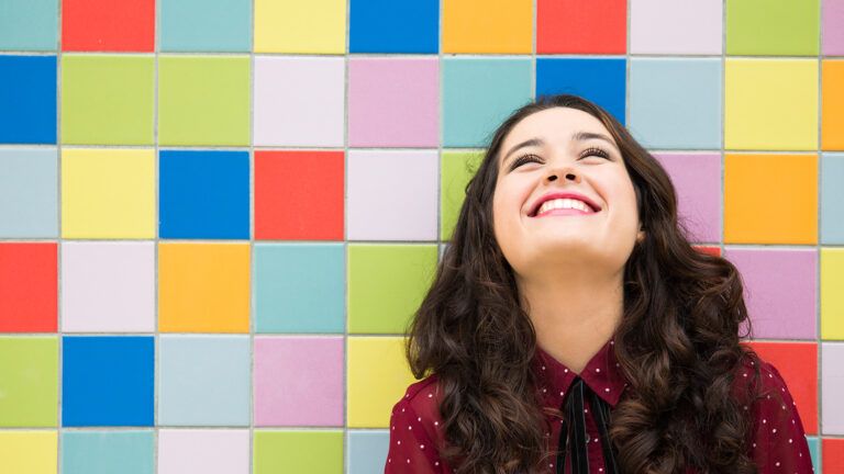 A young woman gazes upward, smiling