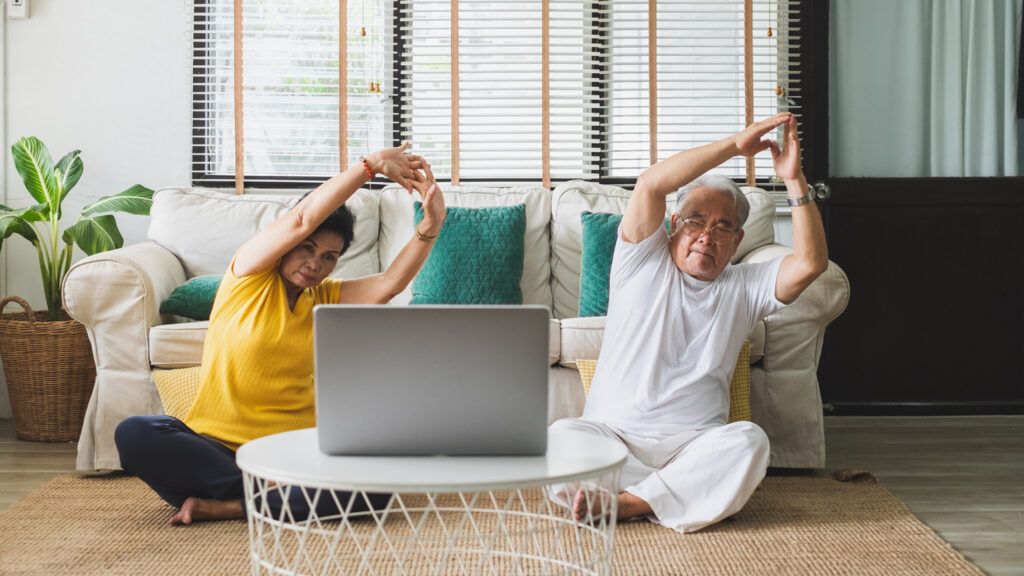 An elderly couple doing an at-home virtual exercise; Getty Images